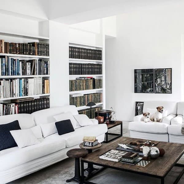 Bright white living room with built-in bookshelves, cozy sofas, and a wooden coffee table.