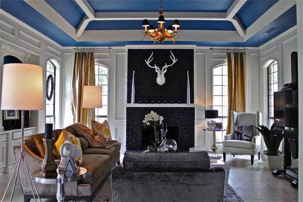 Modern living space with blue coffered ceiling, decorative fireplace, and elegant seating.