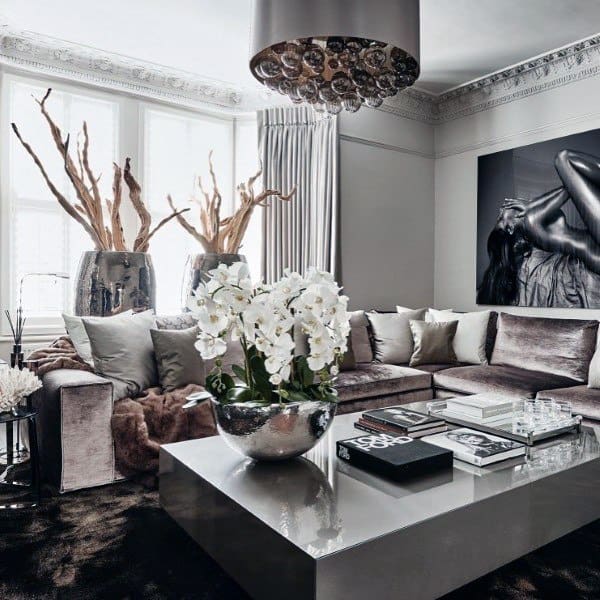 Elegant, neutral living room with a grey sectional sofa, large orchid centerpiece, and abstract wall art