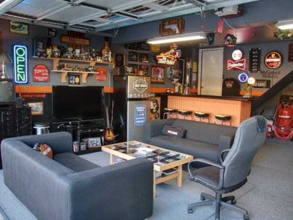 Garage bar with lounge seating, neon signs, Harley-Davidson decor, and a cozy entertainment setup.21