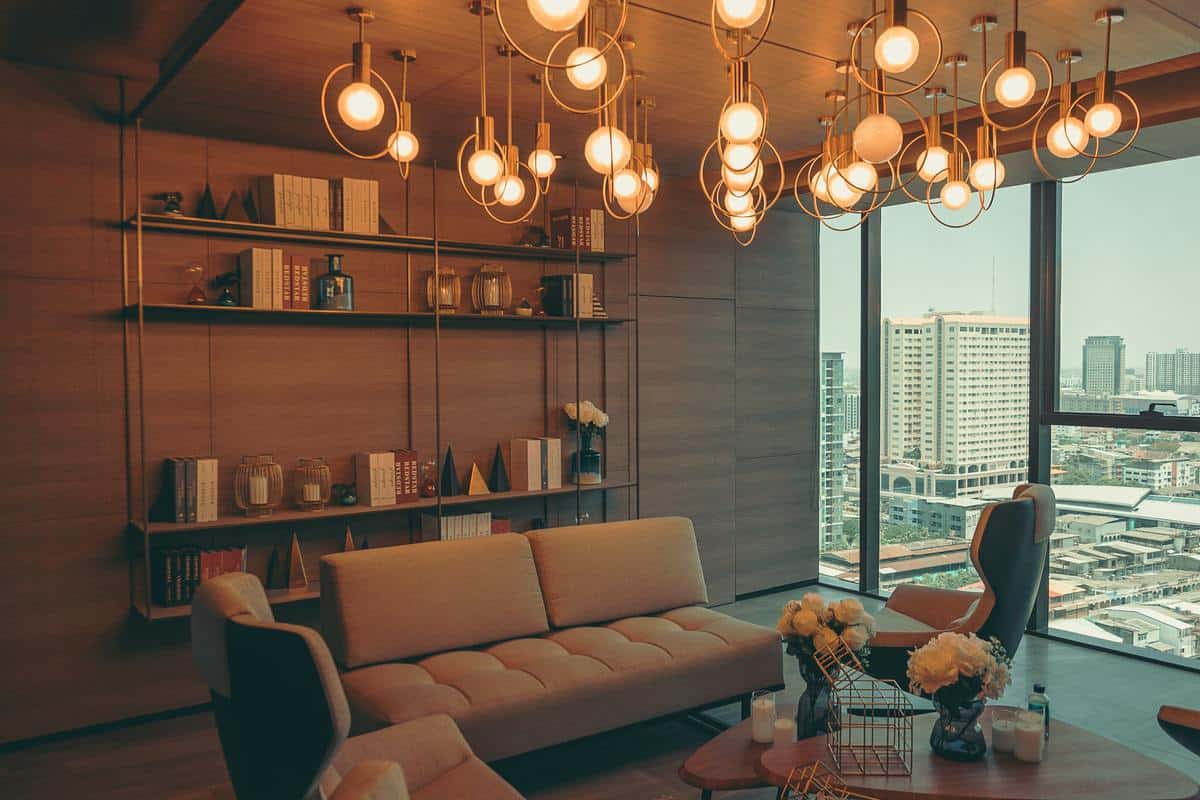 Modern living room with elegant lighting, beige and brown furniture, large windows overlooking a cityscape