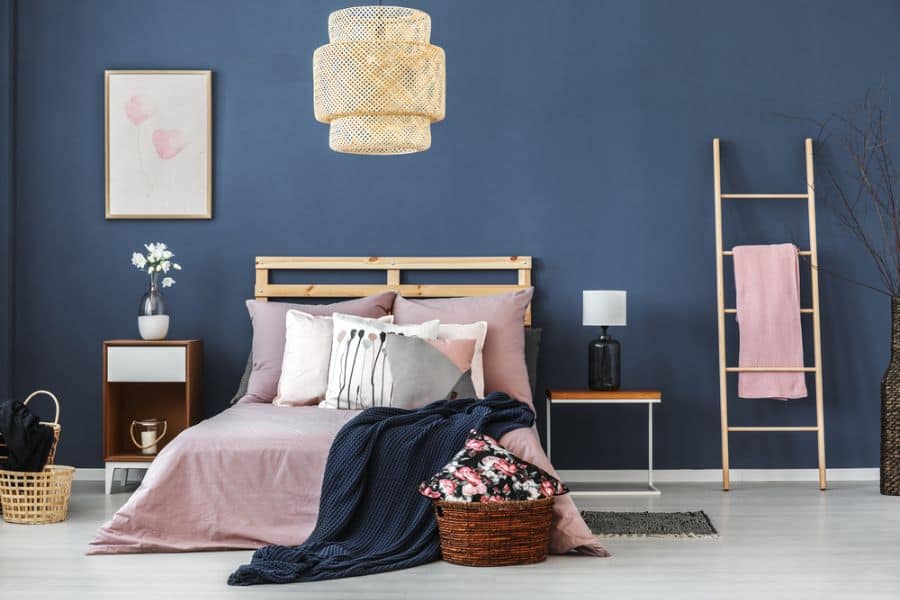 Blue bedroom with wood crate bed, woven pendant light, and decorative ladder.