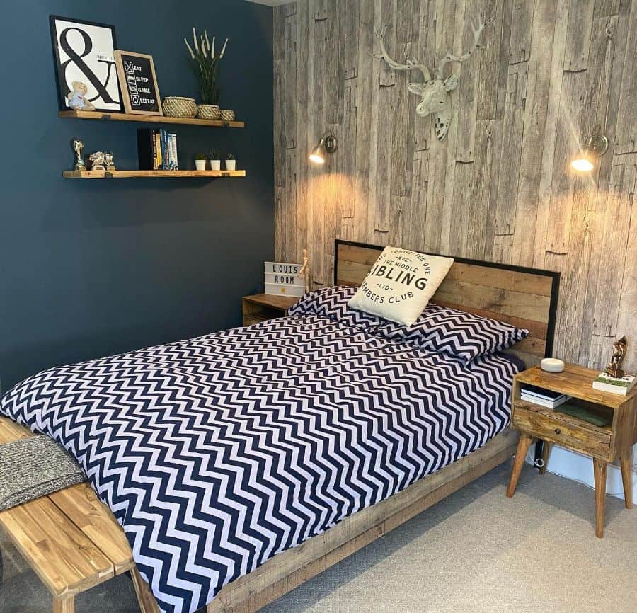 Rustic bedroom with wood accent wall, moose head decor, and wooden furniture.