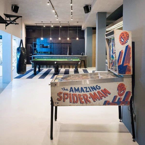 Game room with The Amazing Spider-Man pinball machine, pool table, punching bag, and modern decor