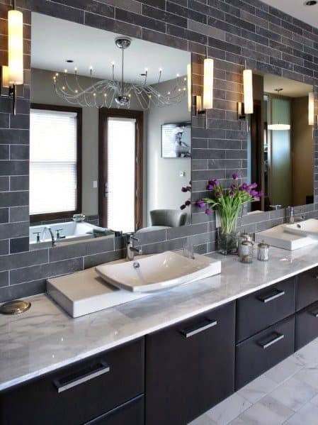 Modern bathroom with dual sinks, large mirrors, and grey accents highlighting purple flowers