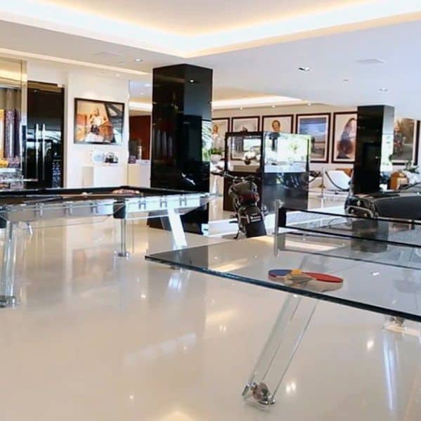 Sleek motorbike showroom with glass tables, glossy floors, and framed artwork on the walls.