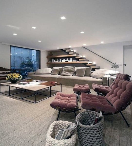 downstairs living room long gray sofa two maroon eames chairs 