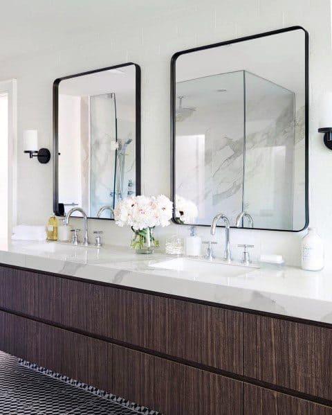 Modern bathroom with floating double vanity, black framed mirrors, and marble countertop.