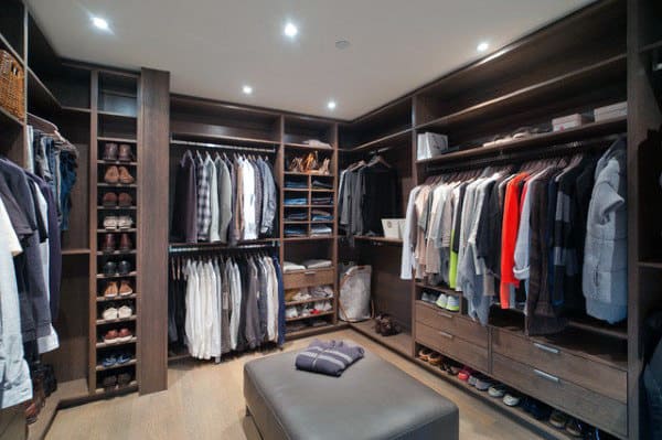 A spacious walk-in closet with clothes, shoes, and accessories neatly organized on shelves and hangers