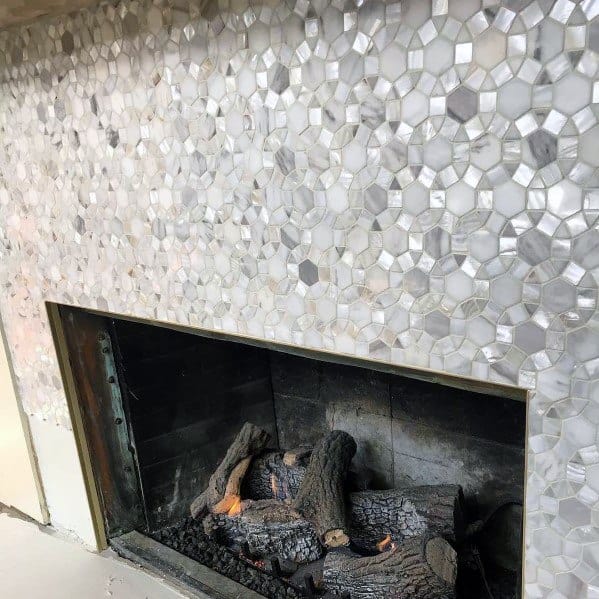 A fireplace adorned with shimmering metallic mosaic tiles, creating a dazzling and luxurious focal point.