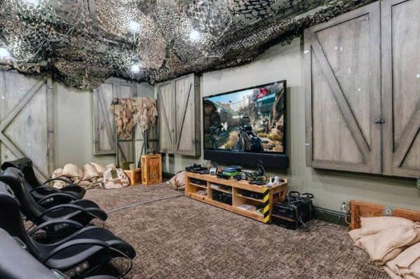 Home theater with gaming setup, large screen, camouflage decor, and comfortable seating