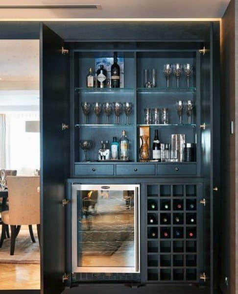 Modern mini bar with glass shelves, wine fridge, bottle rack, and sleek dark cabinetry.