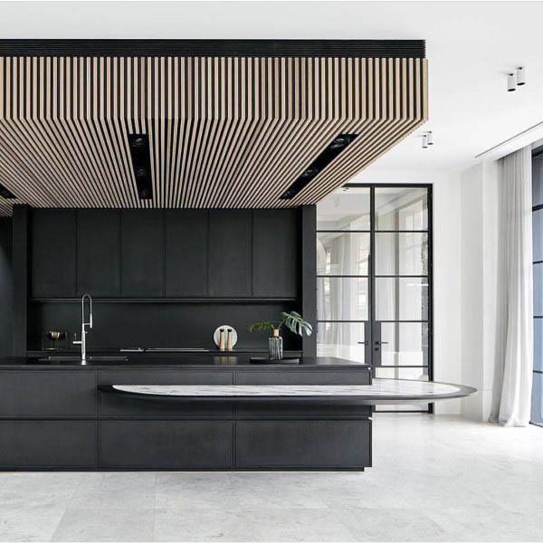 Sleek black kitchen with minimalist design, wood slat ceiling, and curved marble countertop.