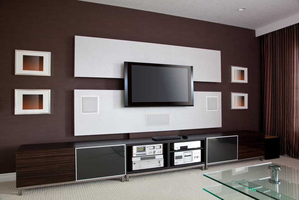 Modern living room with a wall-mounted TV, dark brown media console, and framed decorations