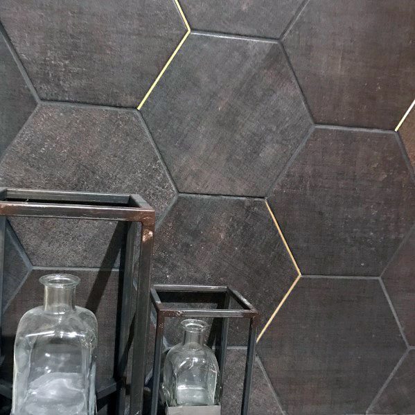 Dark hexagonal tile backsplash with subtle gold accent grout and glass decor pieces.