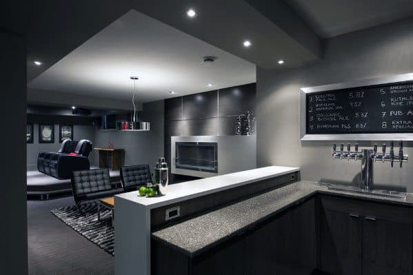 Modern man cave with sleek wet bar, chalkboard beer menu, lounge area, and home theater setup.