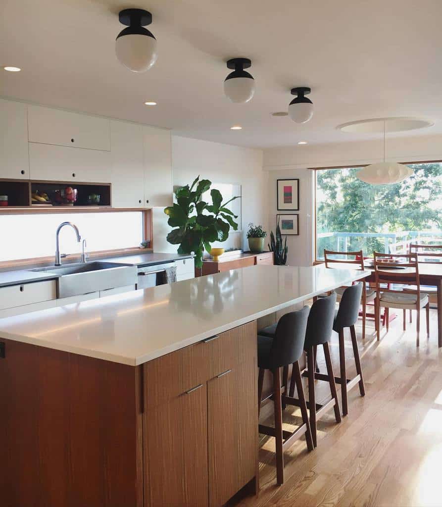 simple kitchen white cabinets wood island white granite countertops three gray seats 