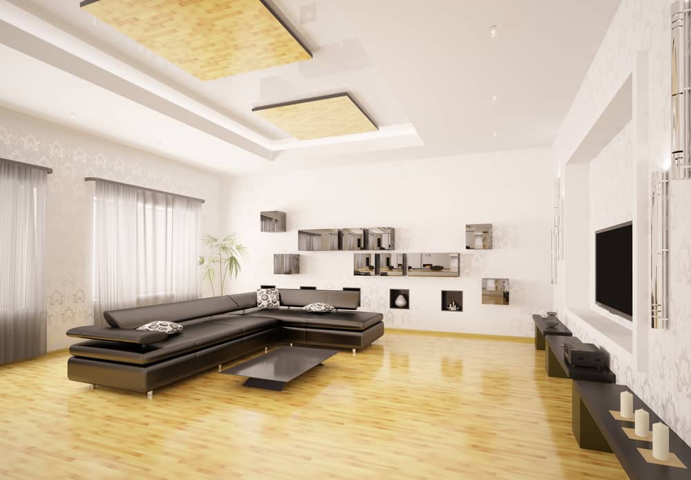 Spacious modern living room with a black leather sectional sofa, mirrored wall shelves, and polished wooden flooring