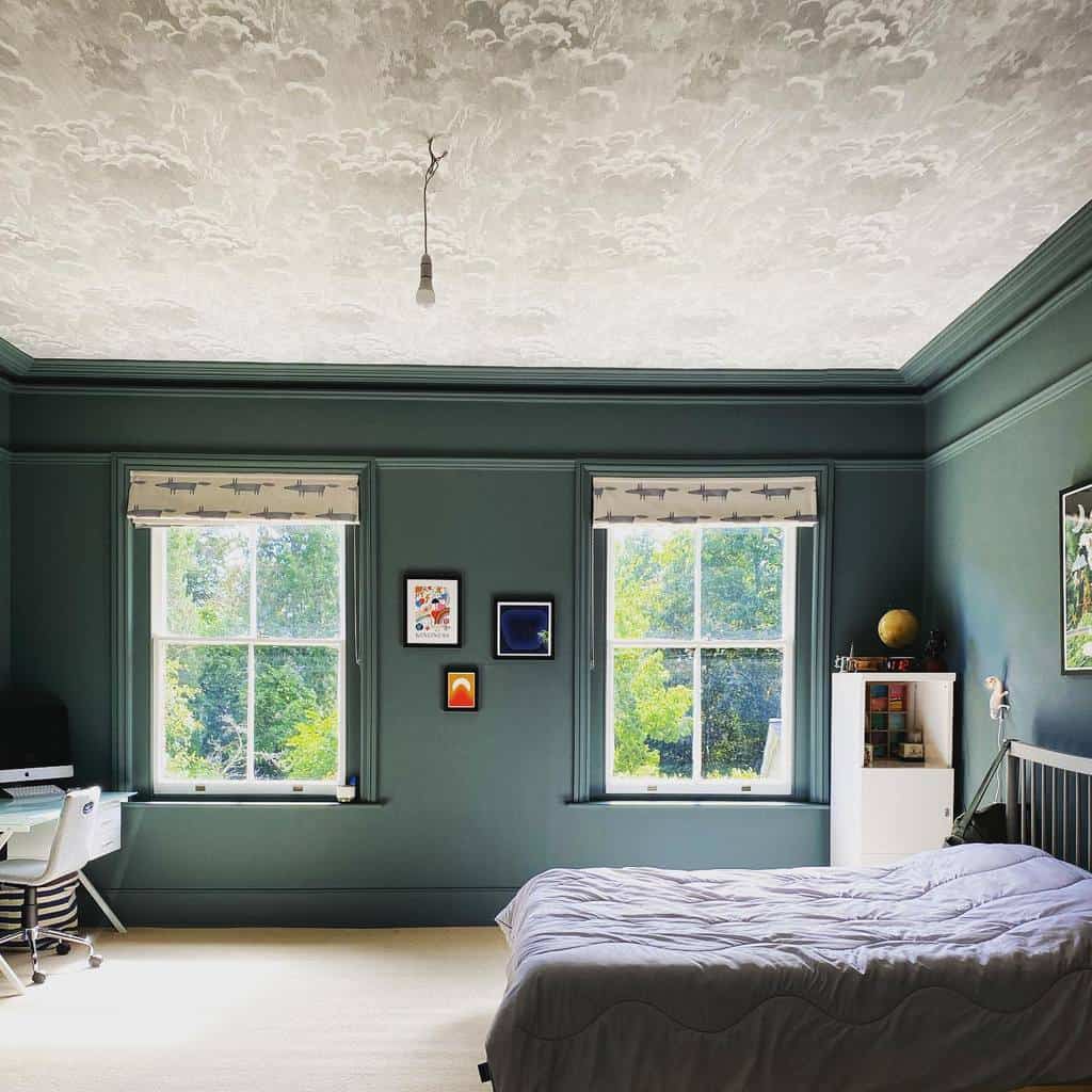 Bedroom with sky mural ceiling, green walls, study desk, and large windows.