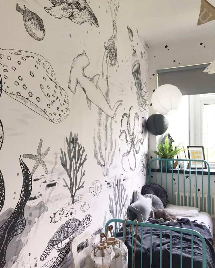 Underwater-themed bedroom mural featuring sea creatures and coral with a cozy kids' bed.