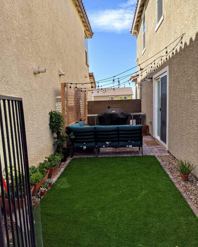 narrow backyard with lawn and brick patio 