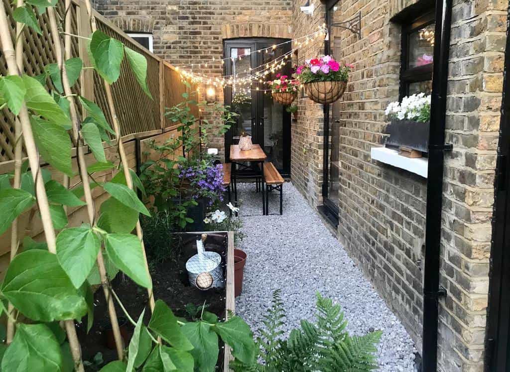 narrow backyard with gravel surface and bench with table 