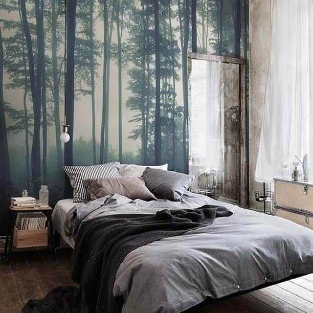 Nature-inspired bedroom featuring forest wallpaper, a floating bed, and cozy decor for a serene ambiance.