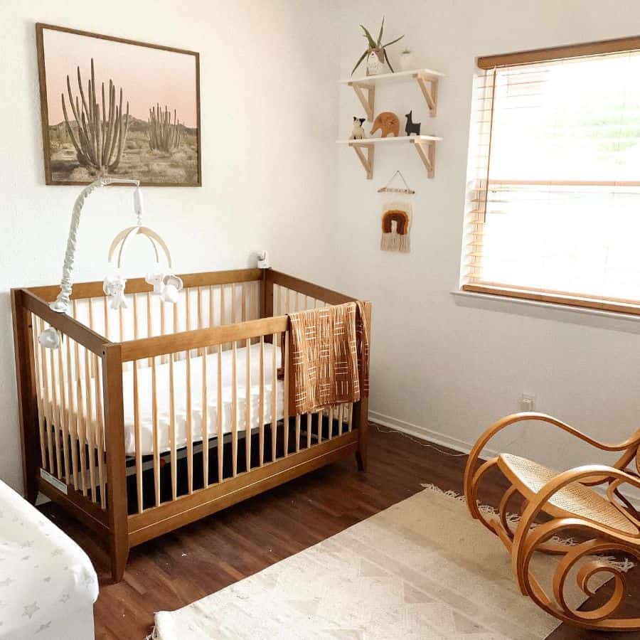 Nature-inspired boho baby room with wooden crib, cactus wall art, and cozy neutral tones throughout the decor.