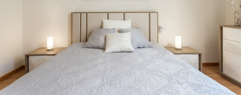 Contemporary bedroom with neutral bedding, soft lighting, and minimalist decor.