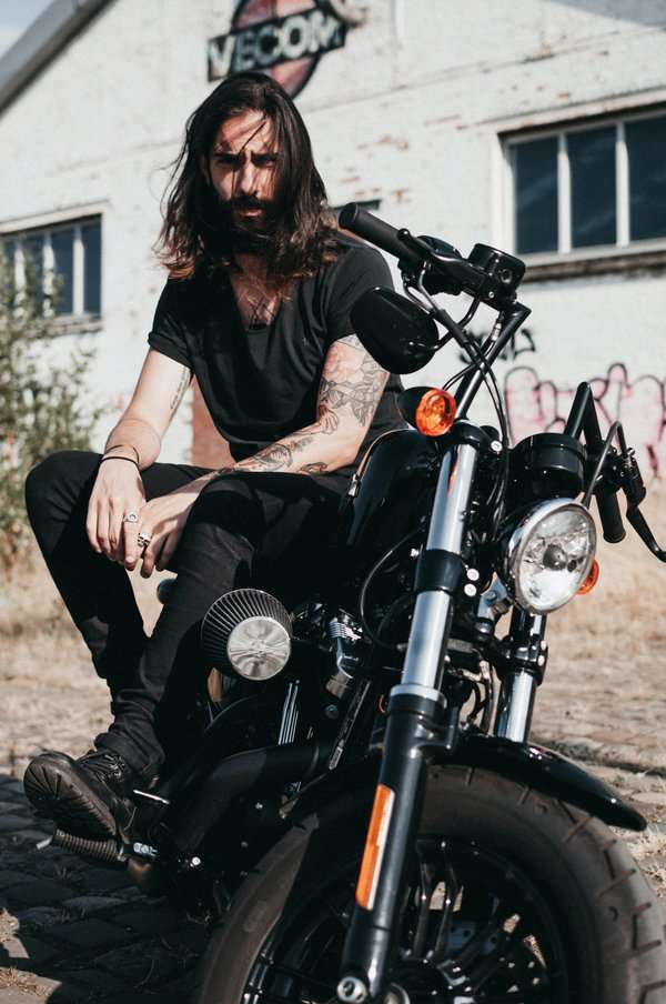 Man sitting on motorcycle with silver rings