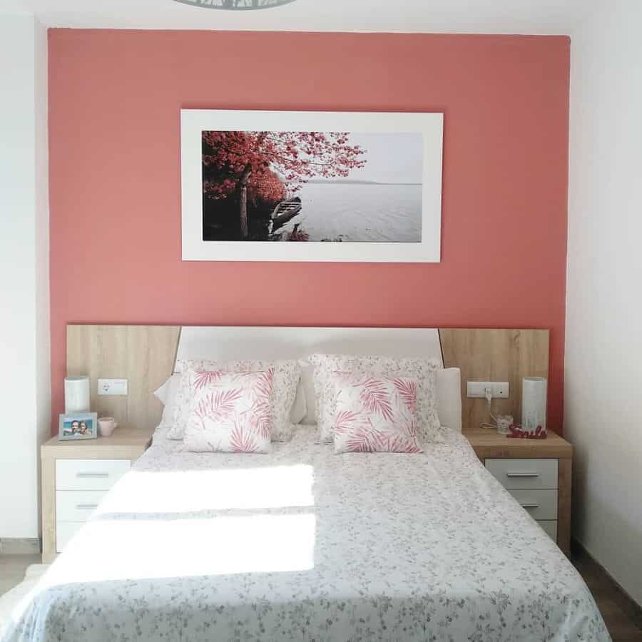 Bedroom with red accent wall, framed artwork, and matching bedside tables.