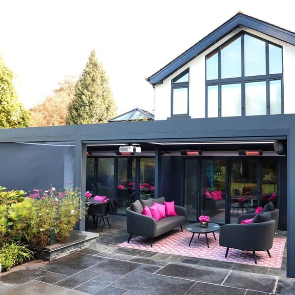 Contemporary outdoor patio with bold pink accents, modern seating, and a sleek, dark pergola