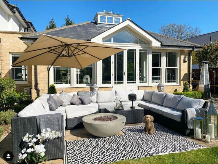 Cozy patio setup with a large sectional sofa and a modern round firepit