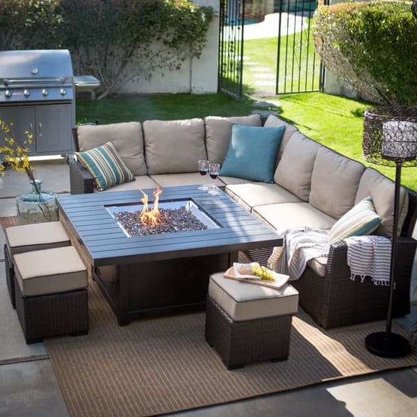 Cozy outdoor patio with a sectional sofa, firepit table, and cushioned ottomans, perfect for relaxing and entertaining