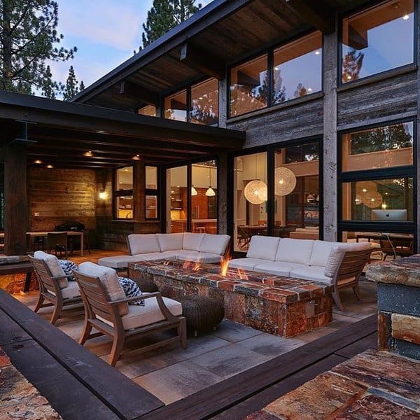 Modern outdoor retreat with a stunning stone firepit, cozy seating, and warm wooden accents, perfect for evening gatherings