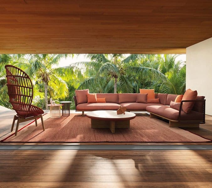 Warm-toned outdoor living area with stylish furniture, surrounded by lush greenery and tropical vibes