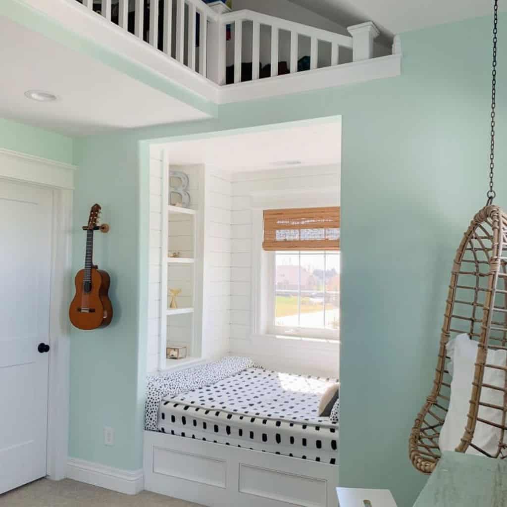 Pastel green bedroom with cozy window nook, hanging chair, and wall-mounted guitar.