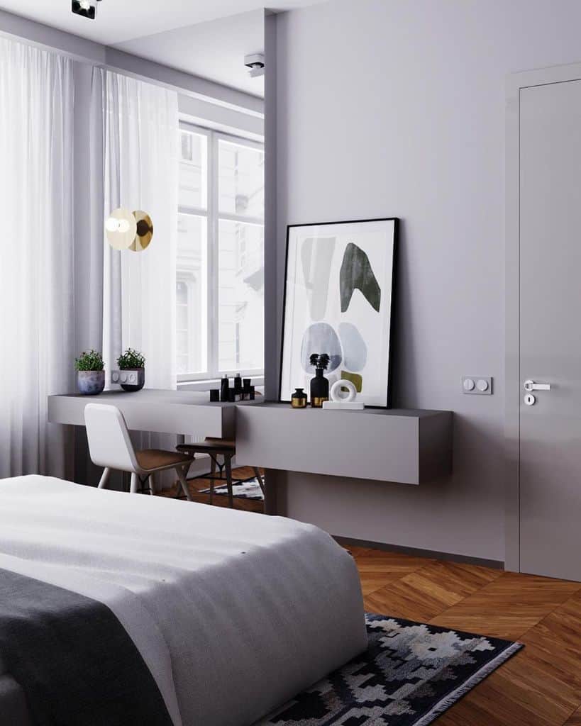 Modern gray bedroom with minimalist vanity, abstract art, and large window.