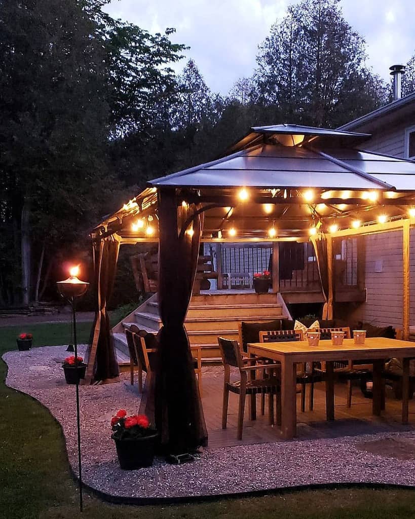 backyard deck and gazebo wood table and chairs red flowers