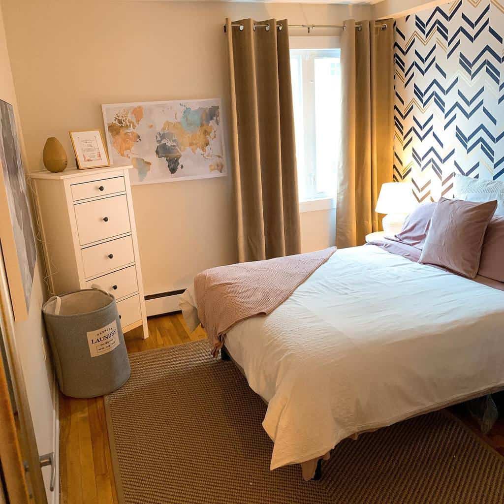 Cozy bedroom with chevron wallpaper, world map wall art, and white storage cabinet.