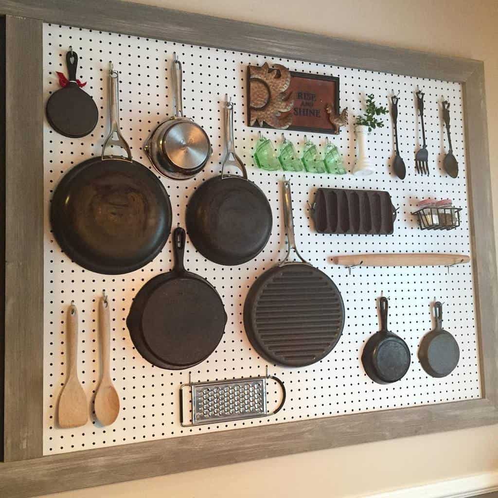 white pegboard in kitchen holding essential utensils