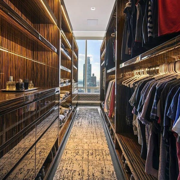 Luxurious walk-in closet with neatly organized clothes and floor-to-ceiling windows showcasing a city view