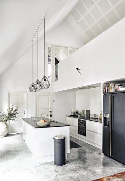 Modern kitchen with polished concrete flooring, sleek white cabinets, pendant lighting, and open shelving