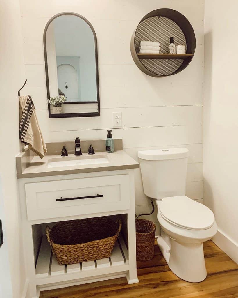 white shiplap wall powder room wall mirror and shelf wicker baskets 