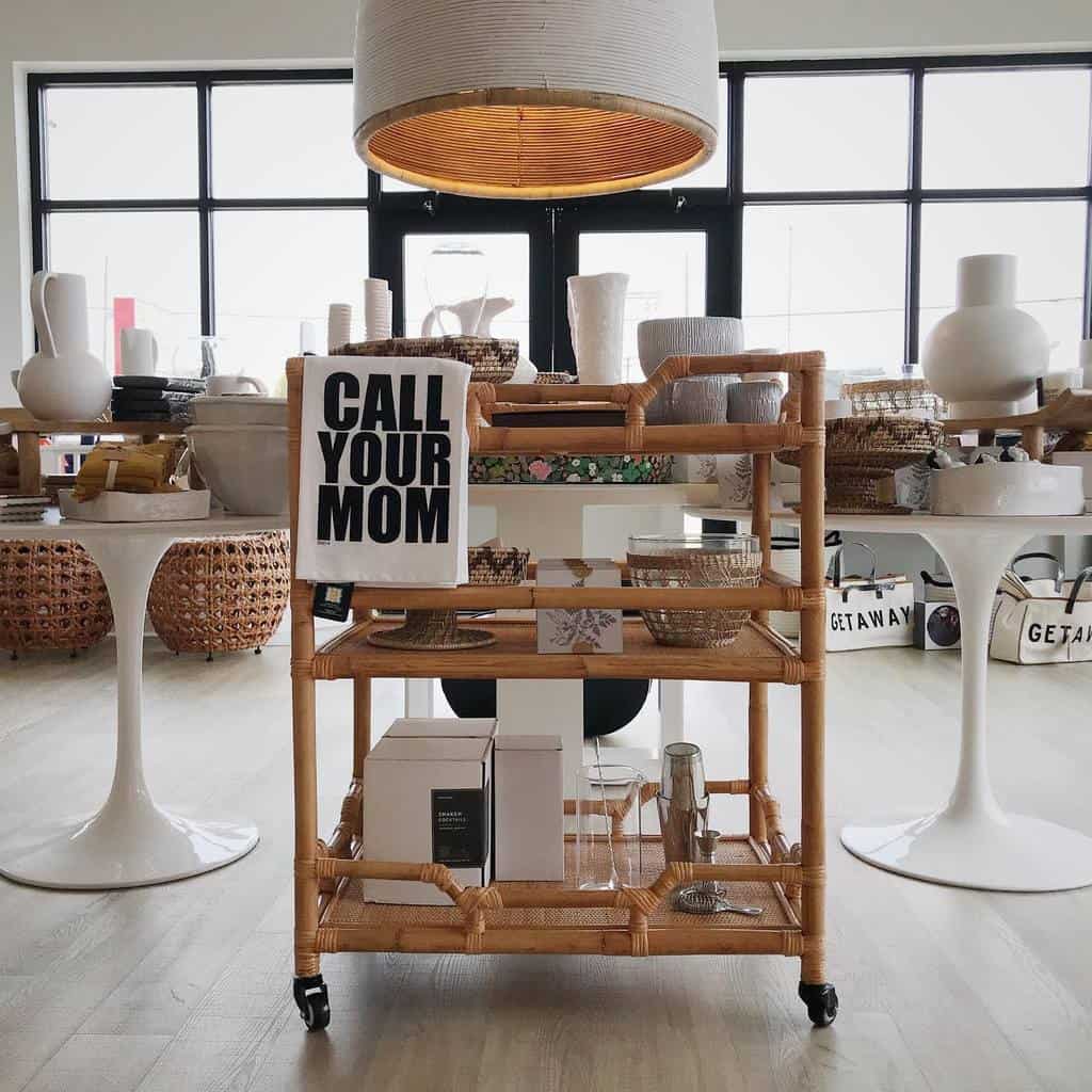 Wicker bar cart with "Call Your Mom" towel, decorative baskets, and gift boxes.