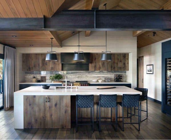 Charming kitchen with rustic wood accents, featuring industrial-style pendant lights above a white island, complemented by woven bar stools and exposed wooden beams