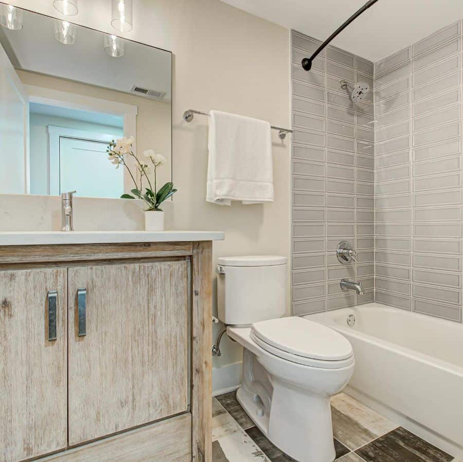 Rustic basement bathroom with wood vanity, tiled shower, and neutral tones.