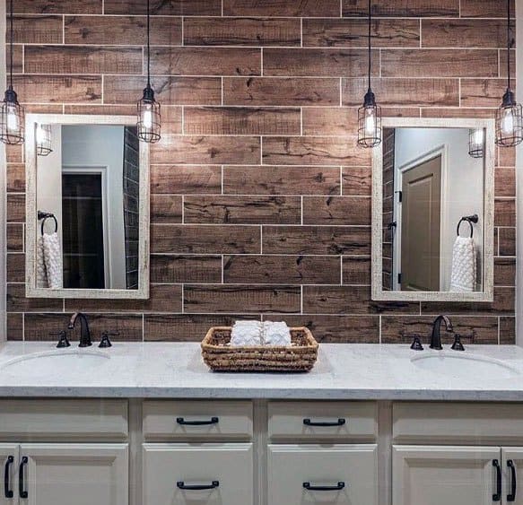 Rustic wood-look tile backsplash with dual sinks, farmhouse lighting, and white cabinetry.