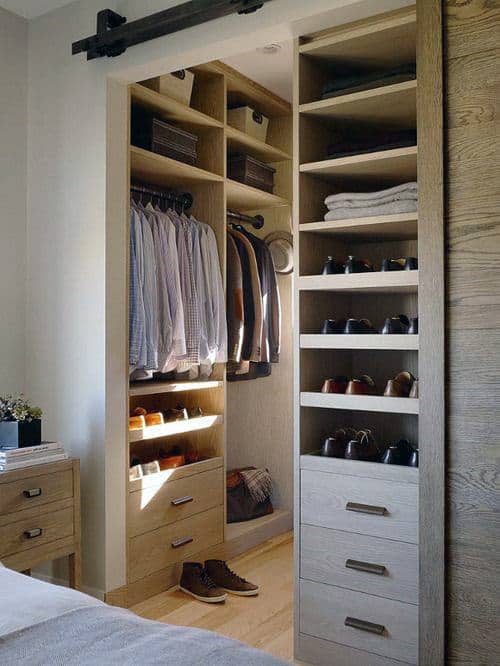 Compact wooden closet with clothes, shoes, and hats neatly organized on shelves and hangers