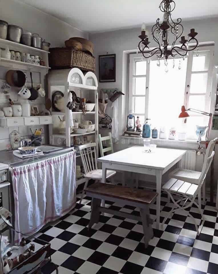 cluttered white rustic kitchen with dining table and chandelier